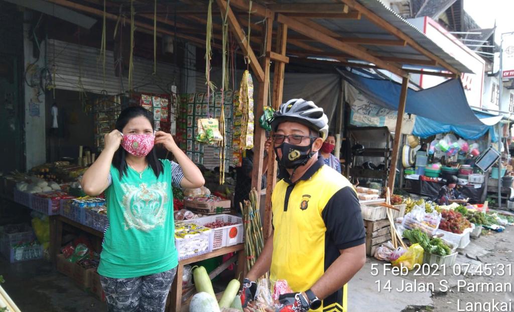 Foto saat Kapolsek Pahandut, Polresta Palangka Raya, Polda Kalteng Kompol Edia Sutaata bagikan masker dam imbau 3M