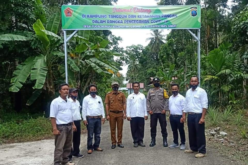 Foto perangkat desa di depan Pemasangan Spanduk "Kampung Tangguh"