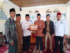 Foto: Ka. Kankemenag  menyerahkan infaq dan juga bingkisan berupa al-Qur'an dan buku tuntunan salat lengkap kepada pengurus Masjid Nurul Iman. 