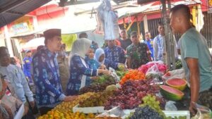Foto: Plt. Bupati Muara Enim, didampingi pejabat terkait sedang berinteraksi dengan pedagang buah. 