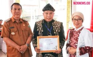 Pj. Bupati didampingi foto bersama dengan Kades Muara Gula Baru memperlihatkan Sertifikat Desa Muara Gula Baru sebagai Desa Anti Korupsi dari KPK (Foto: IST) 