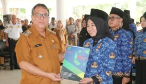 Pj. Bupati menyerahkan surat keputusan Bupati Muara Enim tentang pengangkatan PPPK Formasi Tahun 2022 kepada salah satu pegawai P3K (Foto: IST) 