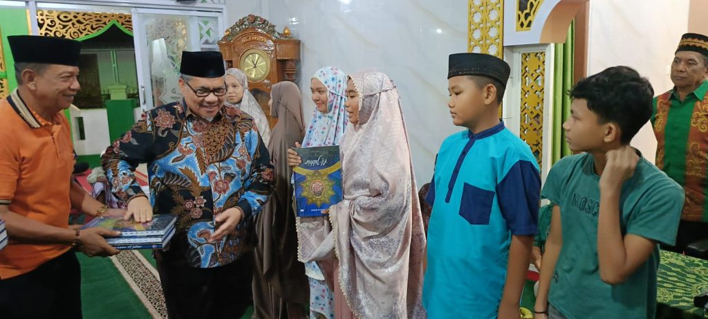 Ketua DPRD Sumatera Barat, Muhidi, menyerahkan 15 mushaf Al-Qur’an kepada anak-anak berprestasi di Masjid Al Furqan, Kelurahan Lubuk Buaya, Kamis (5/3/2026). (Foto: IST)