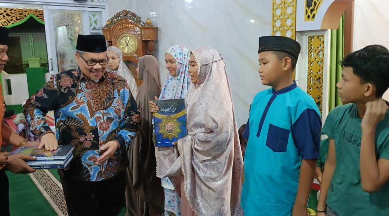 Ketua DPRD Sumatera Barat, Muhidi, menyerahkan 15 mushaf Al-Qur’an kepada anak-anak berprestasi di Masjid Al Furqan, Kelurahan Lubuk Buaya, Kamis (5/3/2026). (Foto: IST)