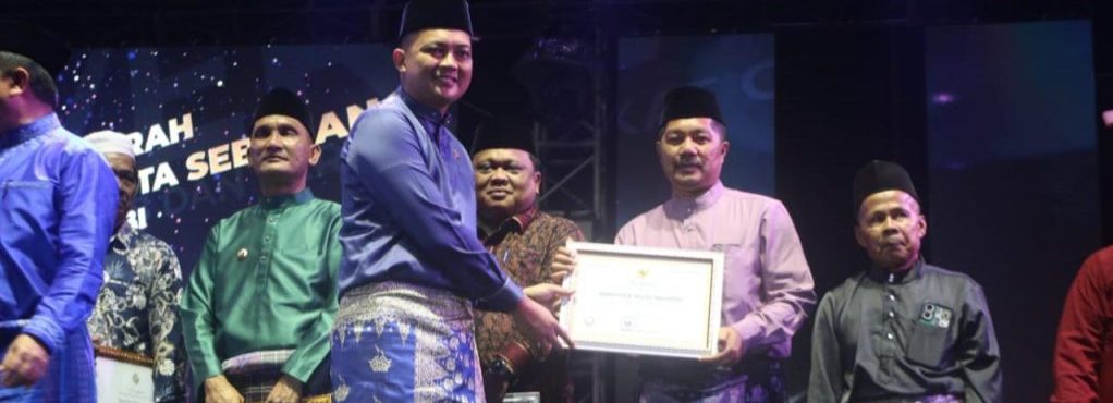 Kabupaten Kerinci kembali menorehkan prestasi membanggakan di tingkat nasional melalui kekayaan budayanya. Bupati Kerinci, Monadi, S.Sos., M.Si., menerima dua penganugerahan prestisius dalam acara Malam Keagungan Melayu 2026 yang berlangsung di Arena Eks MTQ Jambi, Selasa malam (6/1/2026). (Foto: Kominfo Kerinci)