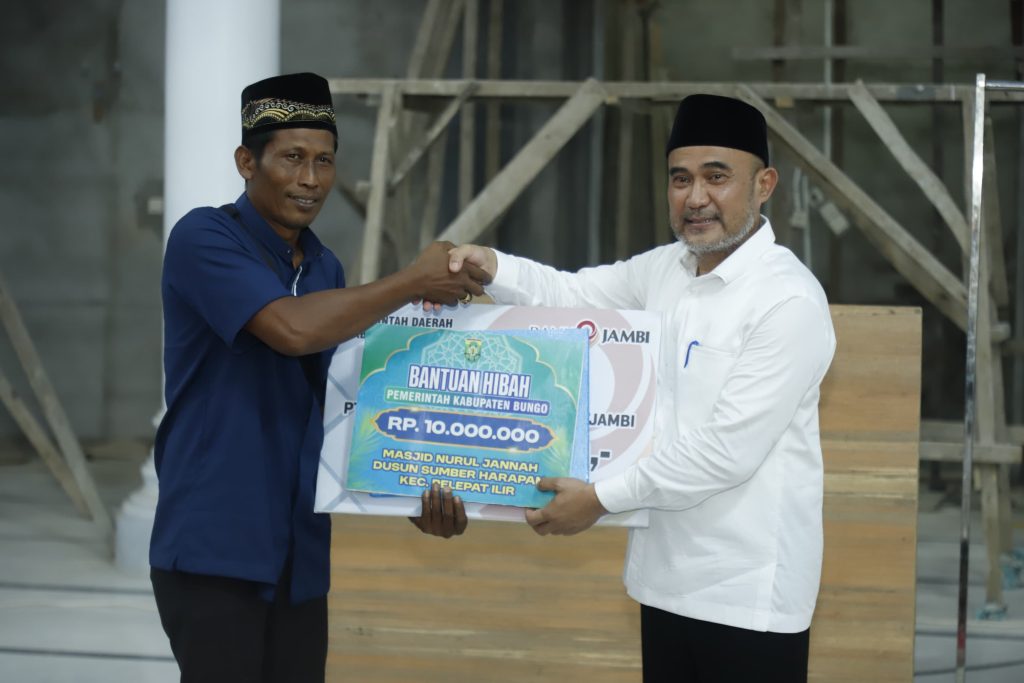 Bupati Bungo H. Dedy Putra menyerahkan bantuan hibah dan CSR Bank Jambi secara simbolis kepada pengurus Masjid Nurul Jannah di Dusun Sumber Harapan, Kecamatan Pelepat Ilir (27/02/2026). Bantuan ini diharapkan dapat mempercepat pembangunan dan meningkatkan kenyamanan jamaah saat beribadah. (Foto: Kominfo Muara Bungo/Ary)