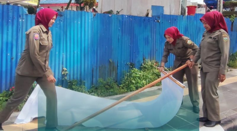 Petugas Satpol PP Damkar Kota Padang Panjang saat mencopot spanduk yang tidak berizin dan rusak di salah satu sudut jalan utama, Sabtu (28/2/2026). Aksi ini bertujuan untuk menjaga keindahan wajah kota serta menjamin keselamatan pengguna jalan dari risiko baliho roboh. (Foto: Kominfo Padang Panjang)