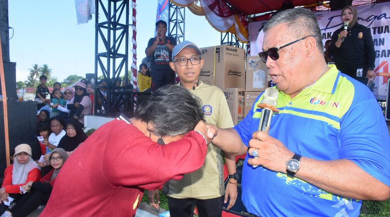 Wakil Bupati Beltim, Khairil Anwar, maju ke panggung untuk mengundi hadiah utama. Di antara sekitar 1.700 peserta, keberuntungan jatuh pada kupon nomor 1121 yang dipegang oleh seorang wanita paruh baya bernama Tanzila (51), Minggu (3/5/2026). (Foto: IST/Imran Elfanani)