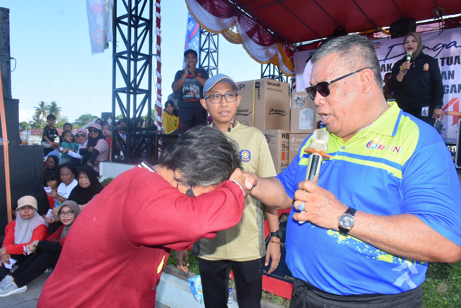 Wakil Bupati Beltim, Khairil Anwar, maju ke panggung untuk mengundi hadiah utama. Di antara sekitar 1.700 peserta, keberuntungan jatuh pada kupon nomor 1121 yang dipegang oleh seorang wanita paruh baya bernama Tanzila (51), Minggu (3/5/2026). (Foto: IST/Imran Elfanani)