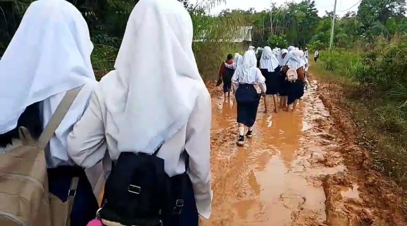 Kondisi jalan rusak dan berlumpur di Desa Muara Jernih, Kecamatan Tabir Ulu, Kabupaten Merangin, Jambi, kian memprihatinkan. Akibatnya, para siswa SMP Negeri 32 Merangin terpaksa berangkat ke sekolah tanpa alas kaki pada Minggu (3/5/2026). (Foto: IST/Dewi Yulianti)