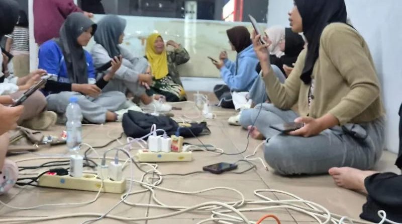 Sejumlah warga mengisi daya gawai di lokasi yang tidak terdampak pemadaman listrik di Kota Padang Jumat (22/5/2026) malam. (Foto: ANTARA/Dokumentasi Pribadi)
