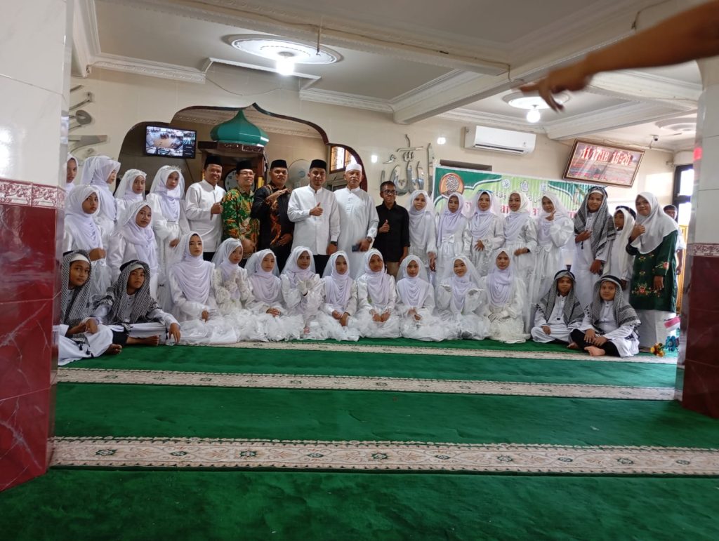Walikota Solok, Kasi PD PP, dan para tamu berfoto bersama dengan santri peserta khatam al-Qur'an di Masjid Irsyadunnas Air Mati Kota Solok. (Foto: IST/Fitria Sartika)