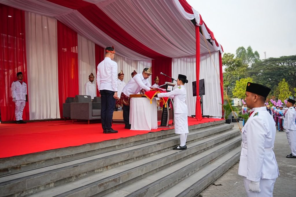 Direktur Utama PTBA, Bambang Ismawan memberikan bendera kepada pembawa baki bendera, Senin (17/8/2026). (Foto: Humas PTBA)