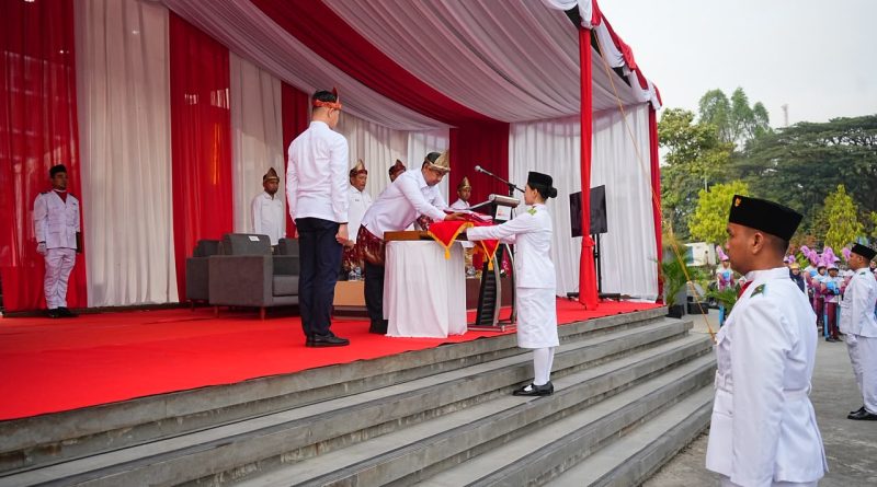 Direktur Utama PTBA, Bambang Ismawan memberikan bendera kepada pembawa baki bendera, Senin (17/8/2026). (Foto: Humas PTBA)