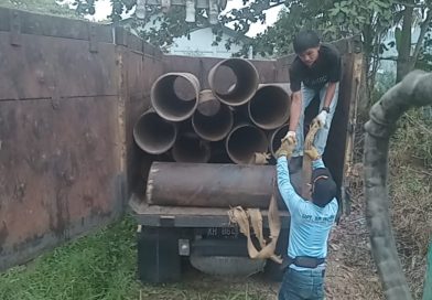 Dua orang warga Desa Muara Wakat saling bantu dalam mengangkat pipa gorong-gorong ke dalam truk. (Foto: IST/Carli Silitonga)