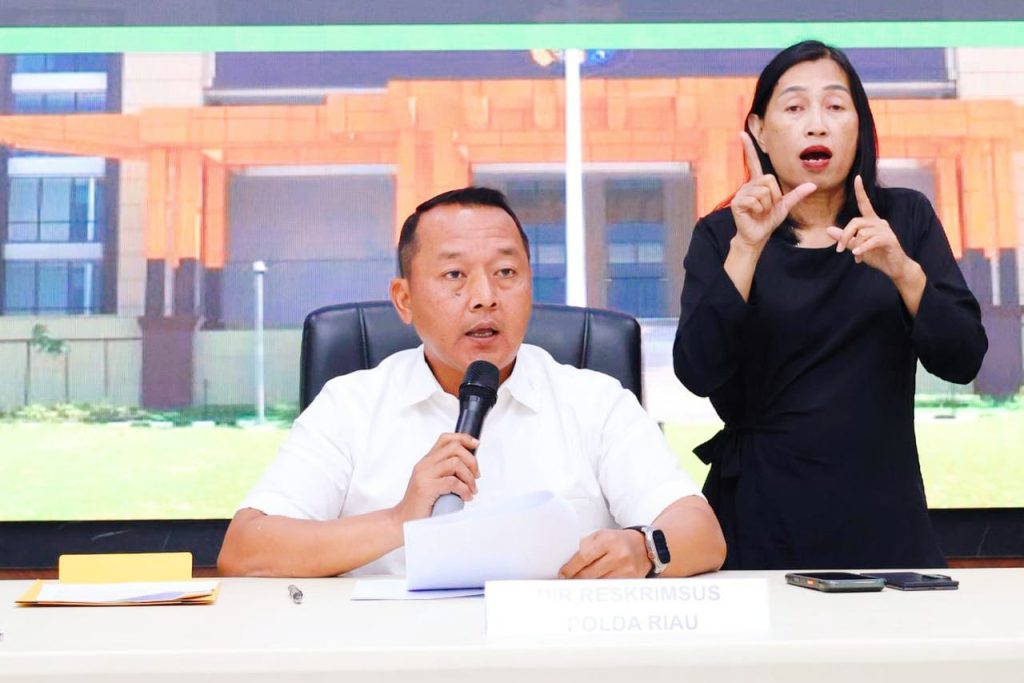 Dirreskrimsus Polda Riau Kombes Pol. Ade Kuncoro Ridwan menyampaikan rilis perkembangan penanganan Karhutla didampingi penerjemah bahasa isyarat di Mapolda Riau, Senin (7/9/2026). (Foto: Humas Polda Riau)